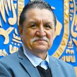 Fernando Rojas Iñiguez, Ph. D. A middle-age man, Fernando Rojas Iñiguez, Ph. D., standing in front of blue and gold logo.