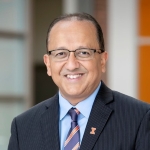 Rashid Bashir, Ph. D. A middle-aged man, Rashid Bashir, Ph. D., portrait with vaulted room in the background.
